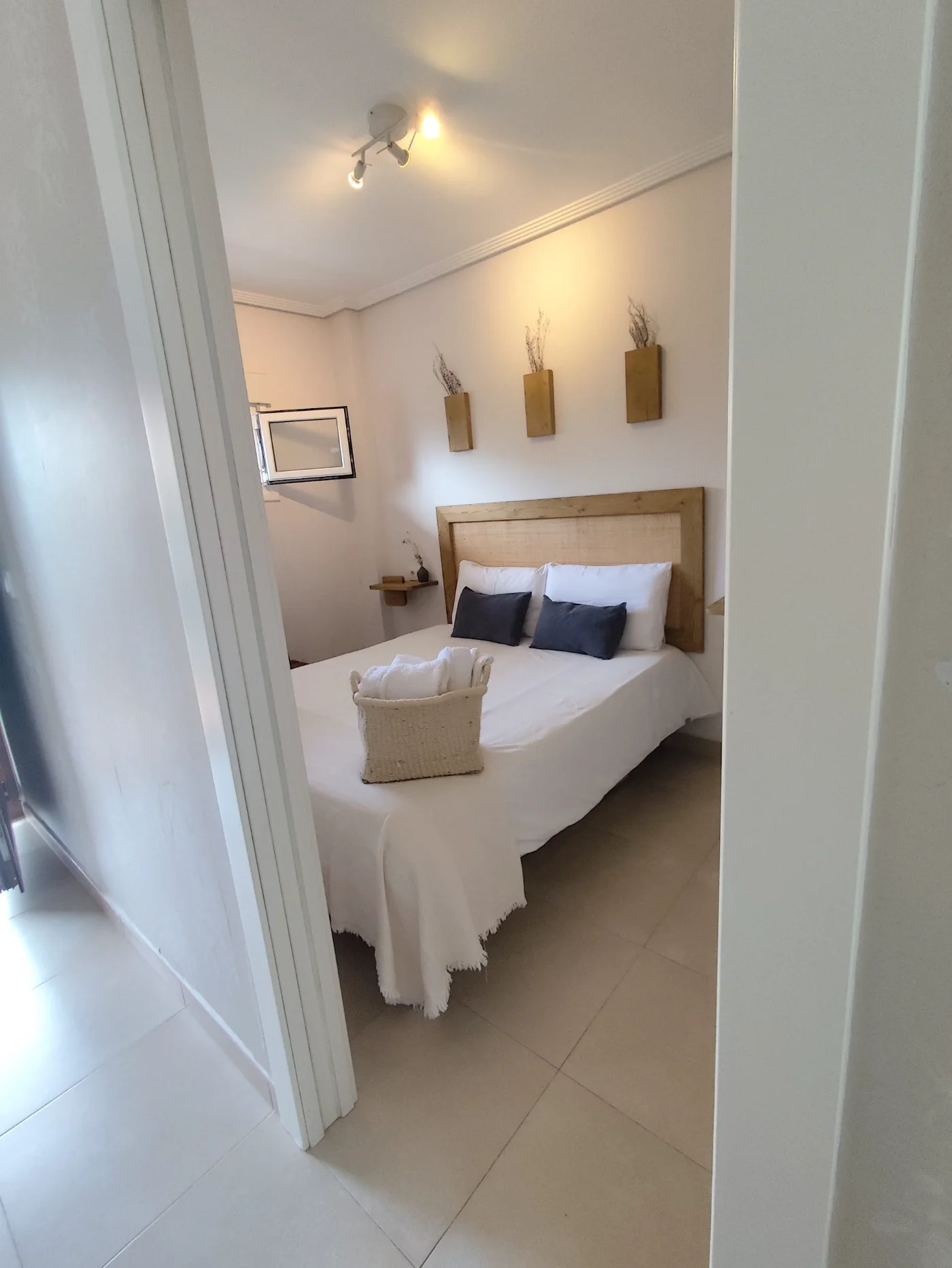 Dormitorio con cama doble y cojines azules