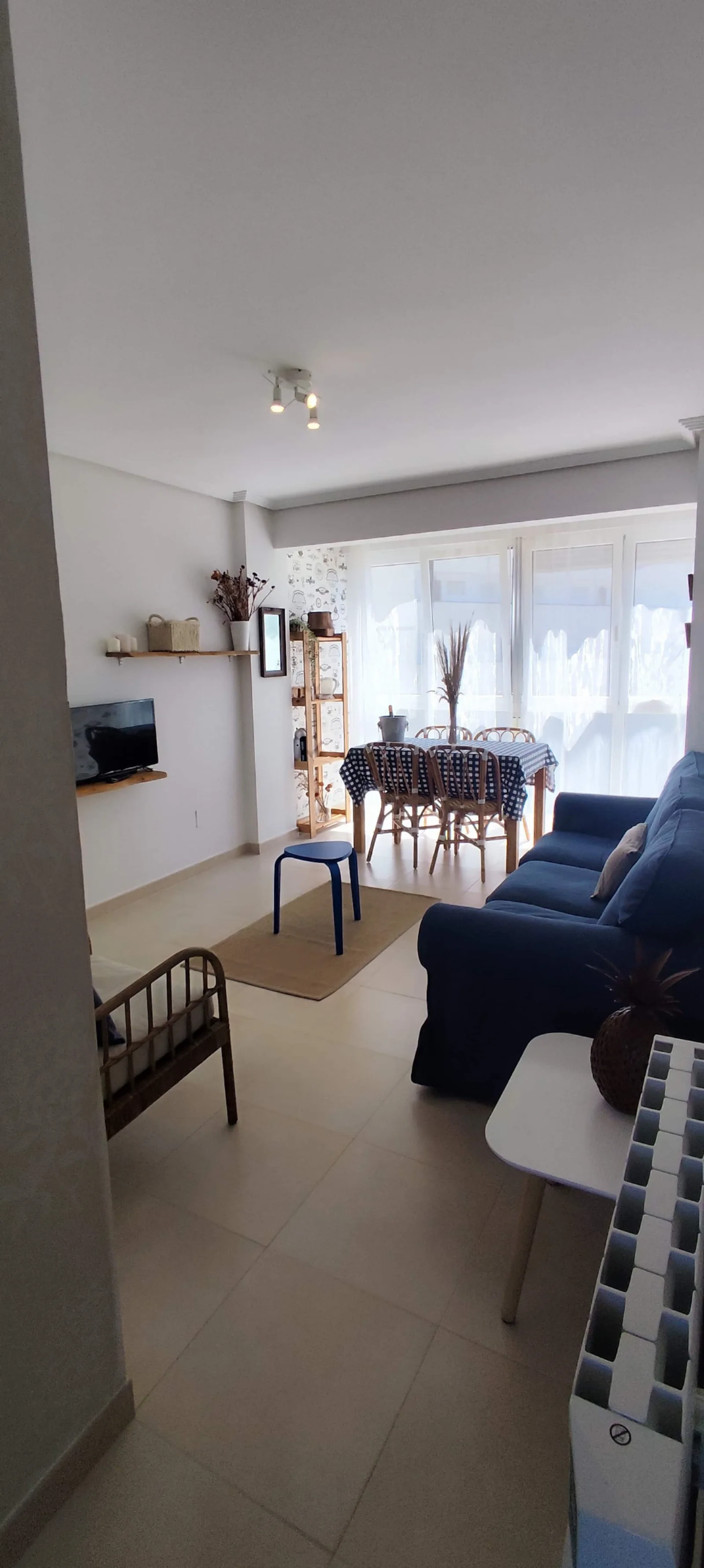 Salón con sofá azul y galería acristalada
