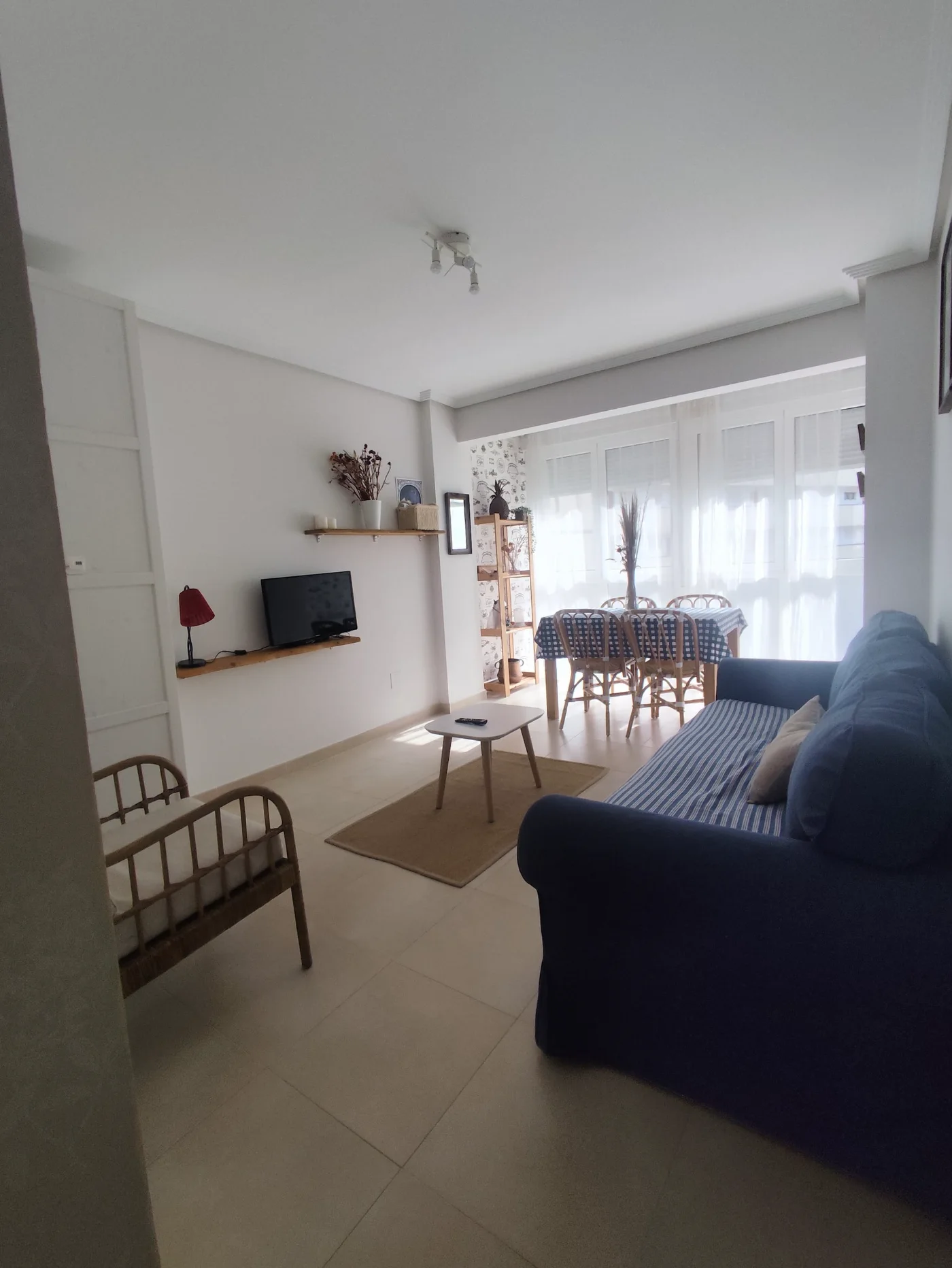Salón con sofá azul y televisión